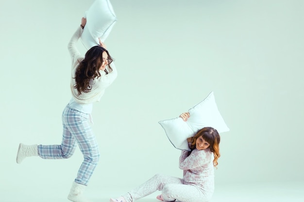 Photo girls in pajamas pillow fighting christmas background