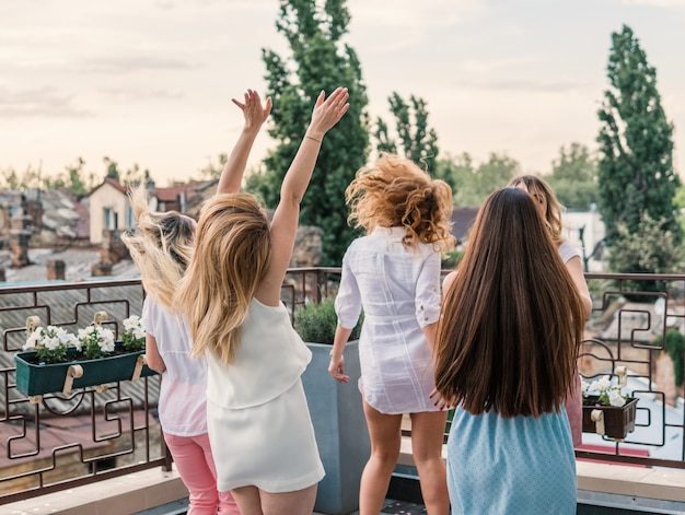 Girls Party. Beautiful Women Friends on the balcony Having Fun At Bachelorette Party. They dance on roof