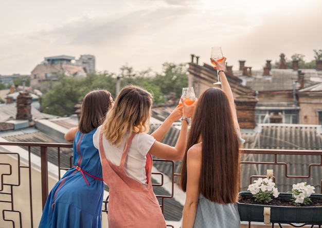 Girls Party. women are standing on the balcony and watching, drinking Champagne