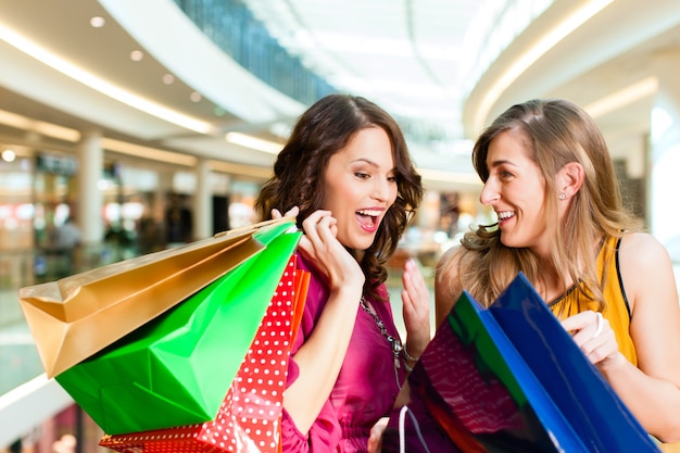 girls shopping in mall looking in bags