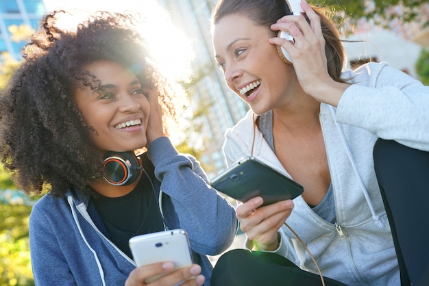 Girls in sports outfit listening to music on smartphone