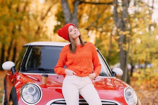 Girls walking in autumn park in red car autumn mood concept