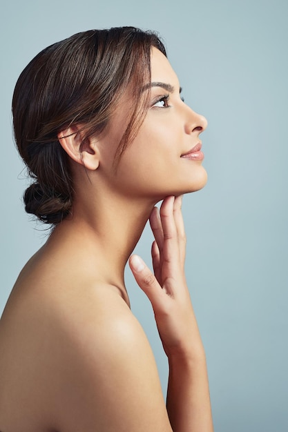 Give a girl the right skincare and shell rule Sideview of a young woman with flawless skin against a grey background