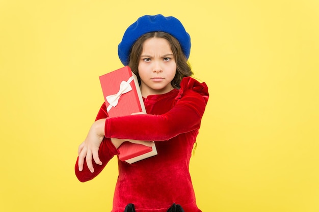 Not give it up mischievous stylish teen girl in french beret hold present box parisian kid with gift elegant child having birthday fashion and beauty successful shopping time childhood