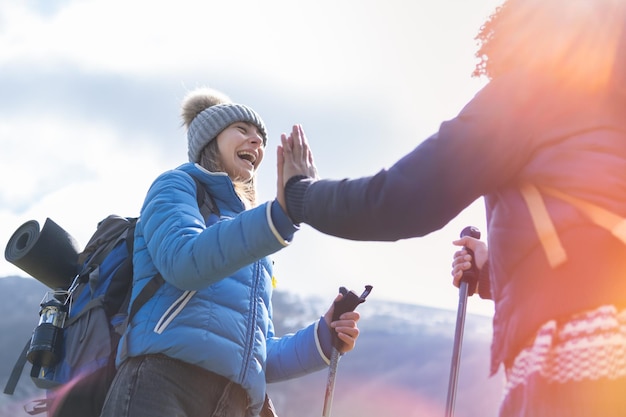 Give me five Joyful satisfied funny hikers holding hands up smiling and gesticulating