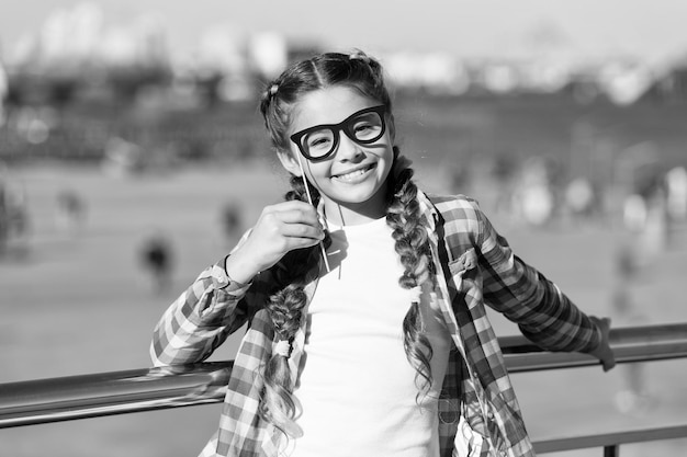 Giving every child a happy childhood Adorable little girl with happy smile and funny look through prop glasses Happy small child with big smile on summer day Happy international childrens day