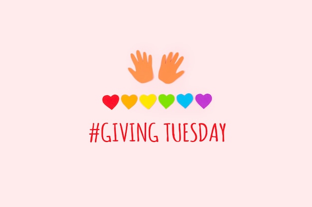 Giving tuesday concept minimal flat lay with text giving tuesday paper palms and rainbow hearts on