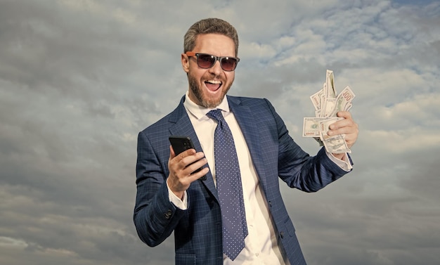 Photo glad betting man with lottery money hold phone photo of betting man with lottery money