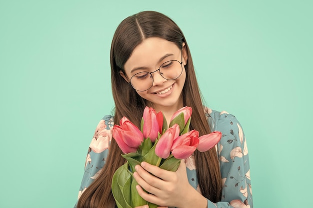 Glad child in glasses with tulips mothers or womens day kid hold flowers for 8 of march