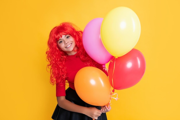 Glad kid with party balloon on yellow background