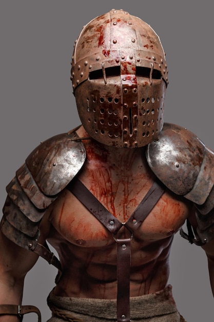 Gladiator in helmet covered in blood. Isolated on grey.