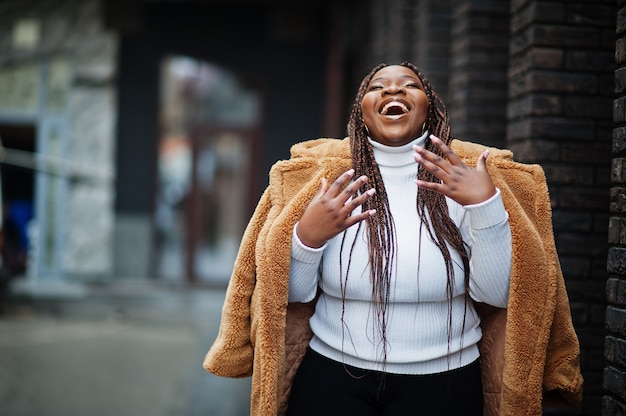 Glamorous african american woman in warm fur coat pose at street.