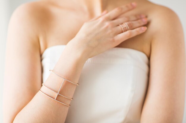 glamour, beauty, jewelry and luxury concept - close up of beautiful woman with golden ring and bracelet