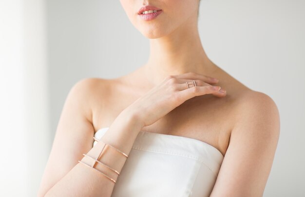 glamour, beauty, jewelry and luxury concept - close up of beautiful woman with golden ring and bracelet