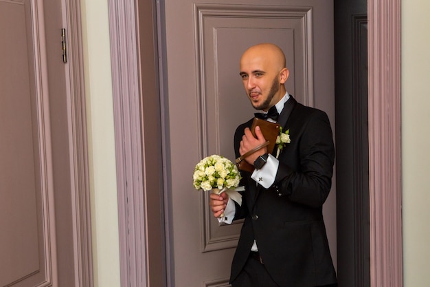 Glamour young husband in a black tuxedo