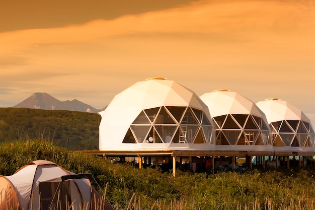 Glamping house in sunset and volcano rural landscape tent houses in Kamchatka peninsula Selective focus