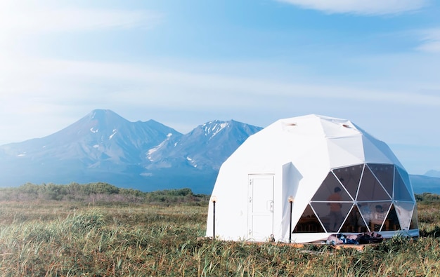 Glamping house in sunset and volcano rural landscape tent houses in Kamchatka peninsula Selective focus