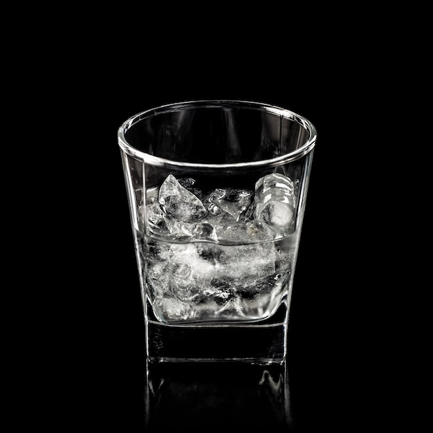 Glass for alcohol with pure ice isolated over black background