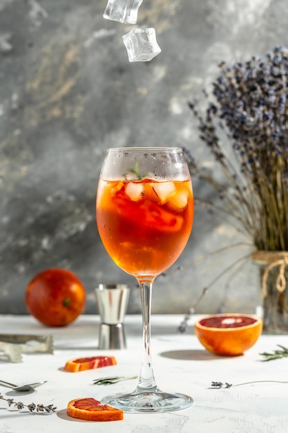 Glass of Aperol spritz cocktail on gray background Italian cocktail with bloody oranges