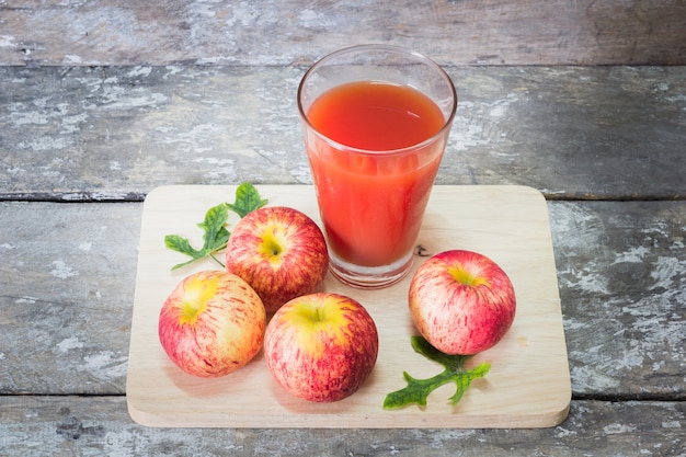 Glass of apple juice on dark wooden table