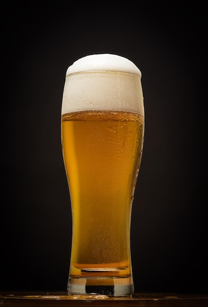 a glass of beer on the black background copyspace space for text