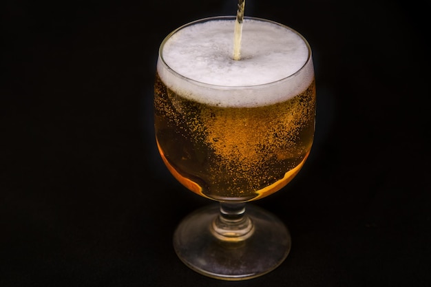 Glass of beer on black background