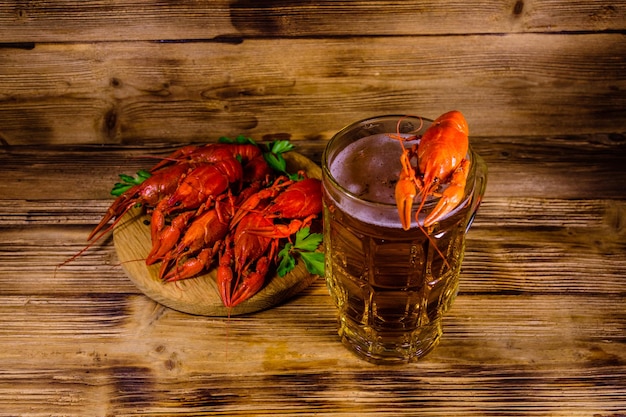 Glass of beer and boiled crayfish on wooden table