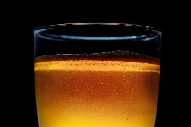 Glass of beer on a dark background. Close-up photo. In the dark key.