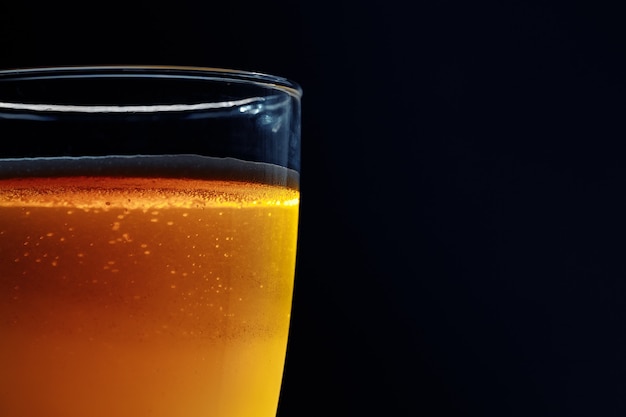 Glass of beer on a dark background. Close-up photo. In the dark key.