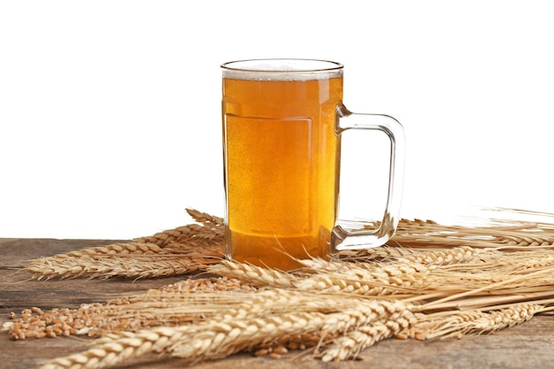 Glass of beer and spikes on wooden table and white background