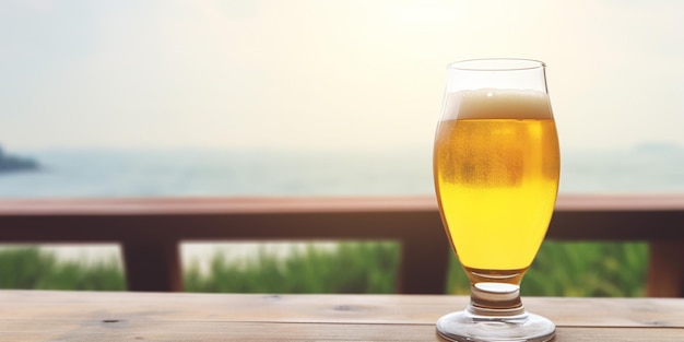 A glass of beer on a table with a view of the ocean in the background