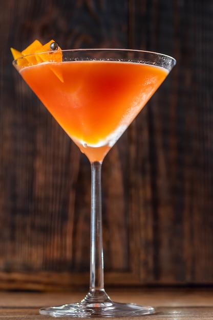 Glass of Blood And Sand Cocktail in martini glass garnished with orange peel