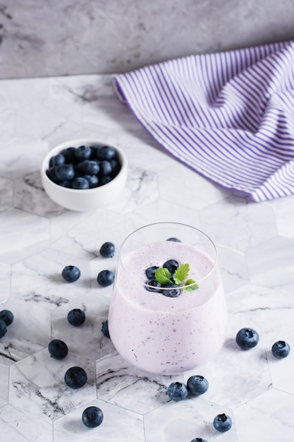 A glass of blueberry smoothie on the table Antioxidant organic healthy food Vertical view