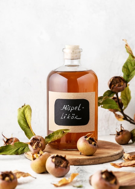 Glass bottle of aromatic homemade medlar fruit liquor with German text on it