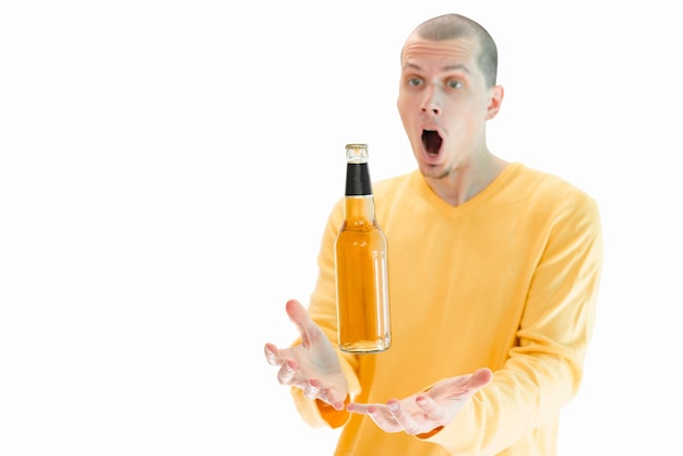 A glass bottle of beer flying above the men's hands isolated on a white background A surprised man with an open mouth Angry Attention Crazy Handsome Hands Guy Reaction Scream Screaming Fun