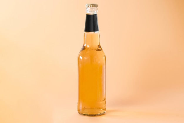 A glass bottle of beer with a black label on the top isolated on an orange background Cool Golden Drunk Fluid Gold Brewed Alcoholic Refreshing Pub Chill Brand Product Bottle