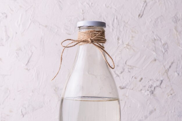 Glass bottle with absolutely clean distilled water isolated on grunge surfaces