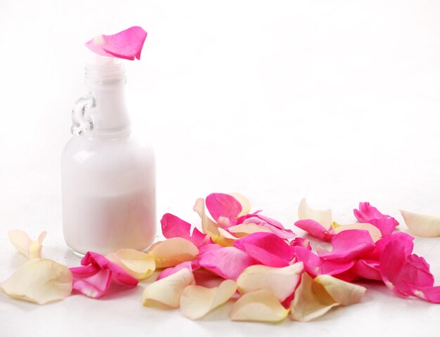 Glass bottle with moisturizer and rose petals