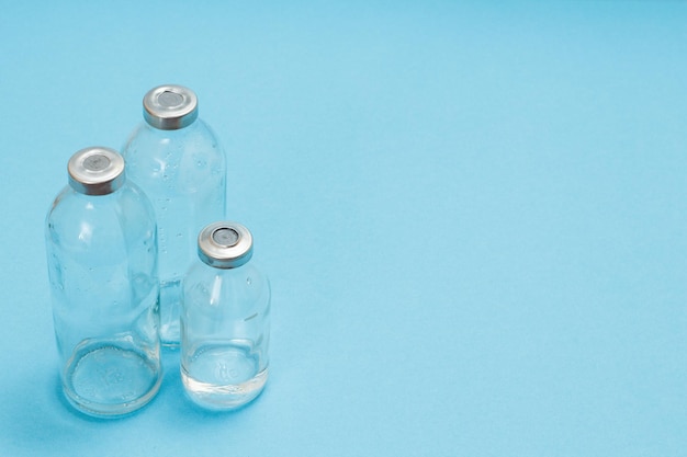 Glass bottles for liquid medicine for injection on a blue background Top view with copy space