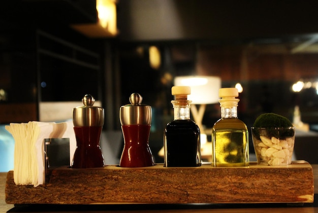 Glass Bottles With Oil, Vinegar, Salt And Pepper Shakers On A Table Setting