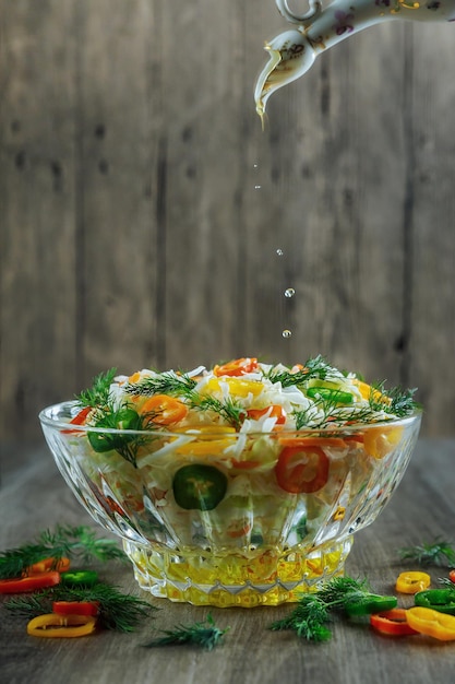 Glass bowl filled with organic super food salad with olive oil red wine vinegar and forks