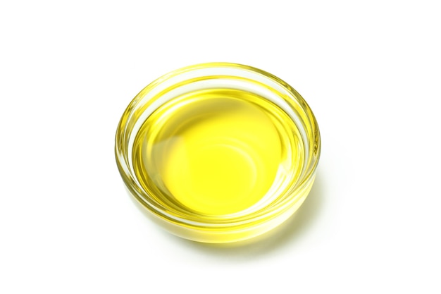 Glass bowl of olive oil isolated on white background