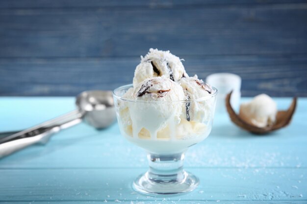 Glass bowl with fresh coconut ice cream on table