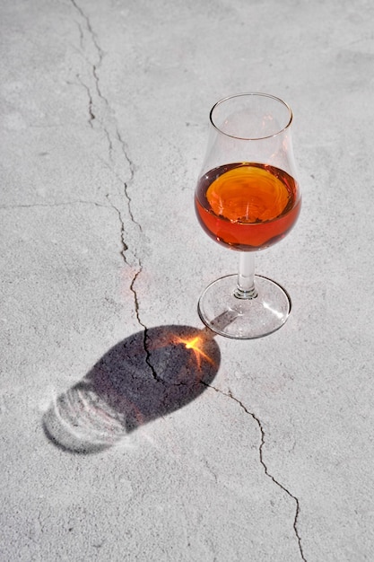 Glass of brandy on concrete surface