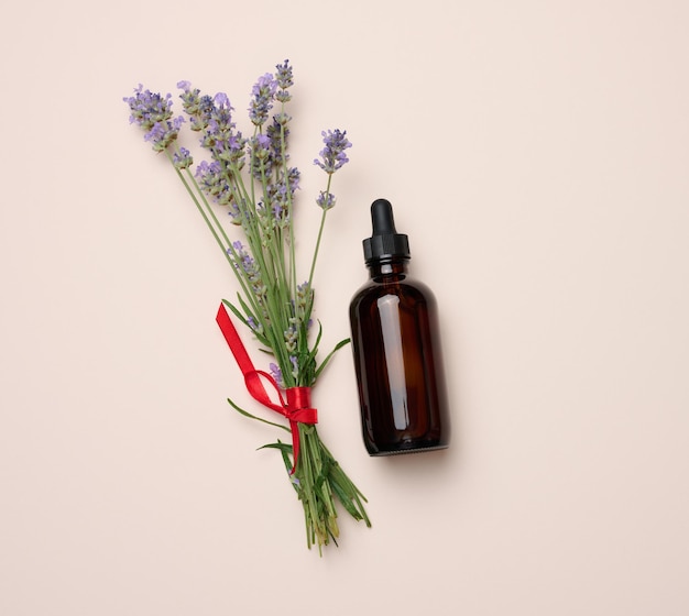 Glass brown bottle with a pipette and a bouquet of lavender