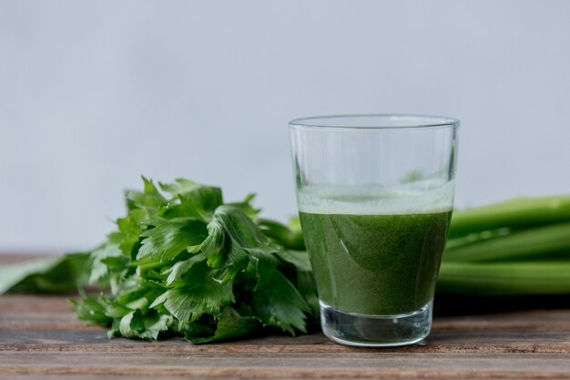 Glass of celery juice on a wooden table