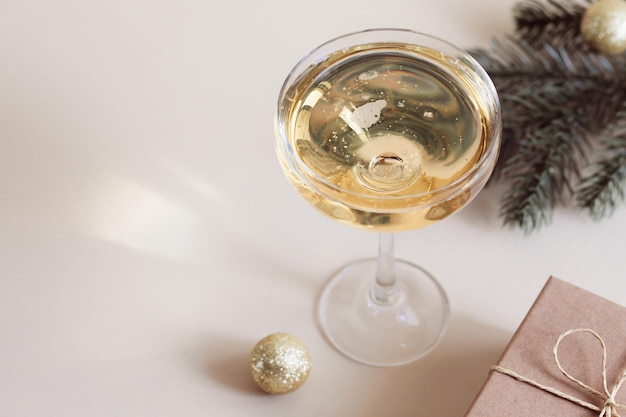 A glass of champagne a gift box and a spruce branch Christmas New Year