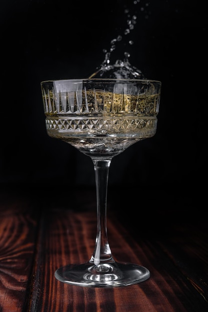 Glass of champagne with splash isolated on black background