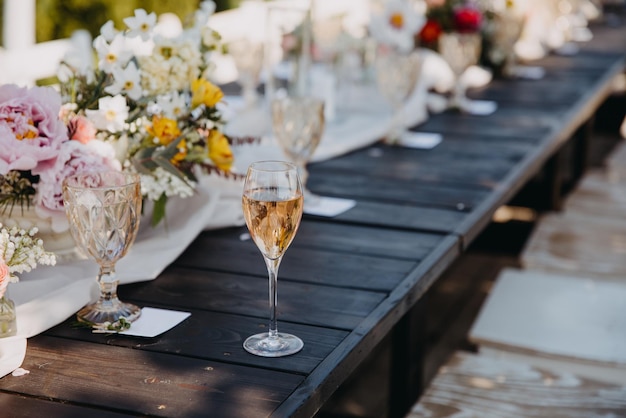 Glass of champagne on a wooden table at an open air party