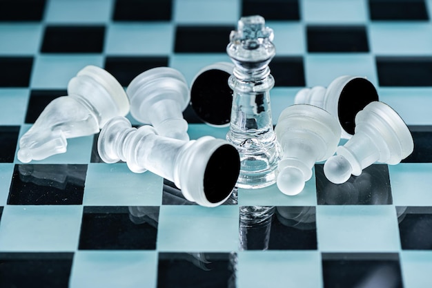 Glass chess board game in black background selective focus on King winner concept